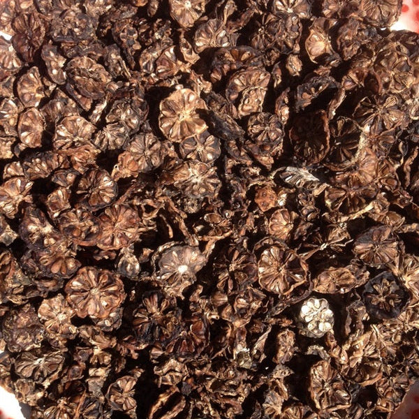 Close-up of dried black peppercorns on a patterned surface