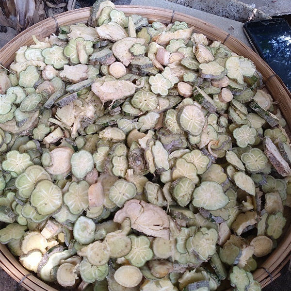 Basket filled with green and brown dried leaves or herbs on a natural background