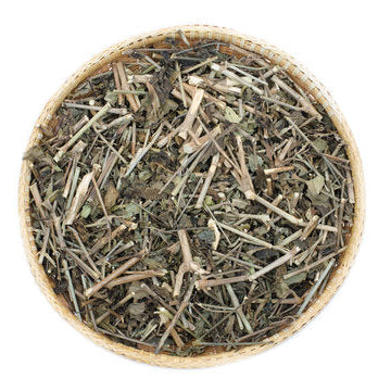 Dried herbs in a woven basket on a white background