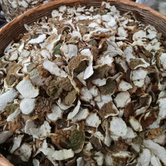 Close-up of dried herbs in a wooden bowl with a blurred background