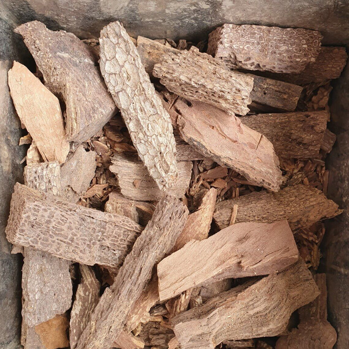 Stack of dried wood pieces in a stone container