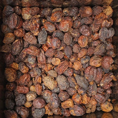 Close-up of dried fruits in a box with 'Som Thai' branding.