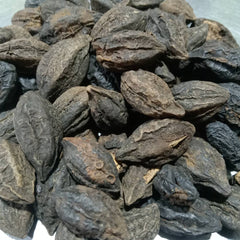 Close-up of dried black pepper seeds on a white background