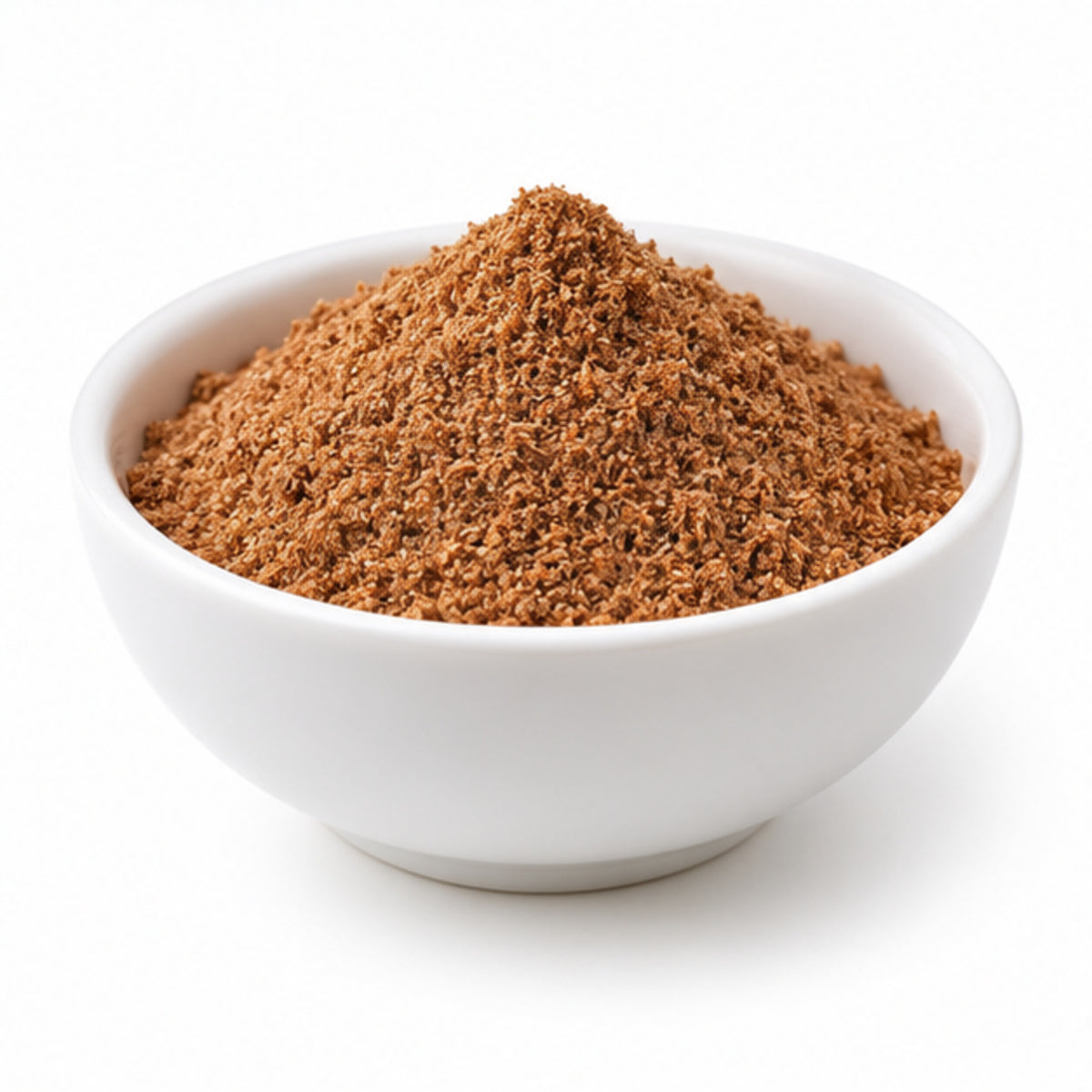 Ground nutmeg powder in a white ceramic bowl