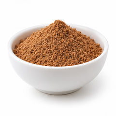 Ground nutmeg powder in a white ceramic bowl