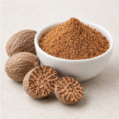 Ground nutmeg powder with whole and halved nutmegs