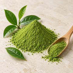 Matcha green tea powder with tea leaves and wooden scoop